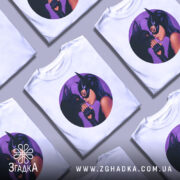 Футболка жінка котик, біла футболка з круглим принтом, на якому зображена жінка в масці, що ніжно торкається носа чорного кота, фон принта фіолетовий, ракурс спереду, на манекені.