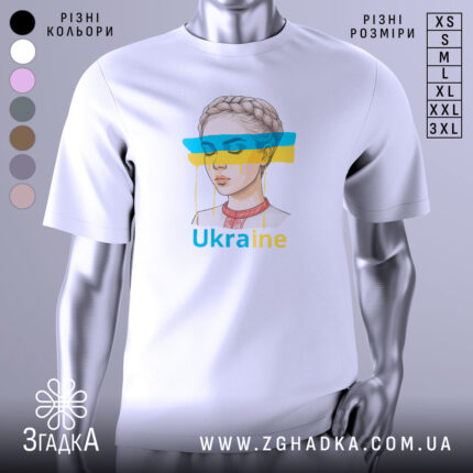 Футболка жіночий образ України, біла, зображена з фронтального ракурсу, фон світло-сірий, принт з малюнком дівчини з косою та кольоровими смугами синього і жовтого кольору, текст 'Ukraine' під малюнком.