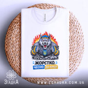 Футболка жорстко чесно до кінця, біла, зображена зверху на плетеній основі, фон світло-сірий, принт з ведмедем у спортивному одязі, що тримає кулаки, з написом 'Жорстко. Чесно. До кінця' у кольорах синьому та жовтому.