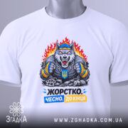 Футболка жорстко чесно до кінця, біла, зображена зверху, фон світло-сірий, принт з ведмедем у спортивному одязі, що тримає кулаки, з написом 'Жорстко. Чесно. До кінця' у кольорах синьому та жовтому, на футболці є етикетка.