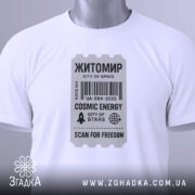 Футболка Житомир білого кольору, складена на поверхні, фон світло-сірий, принт у вигляді квитка з текстом 'Житомир', 'COSMIC ENERGY', 'SCAN FOR FREEDOM' у чорному кольорі, на комірці видніється етикетка.