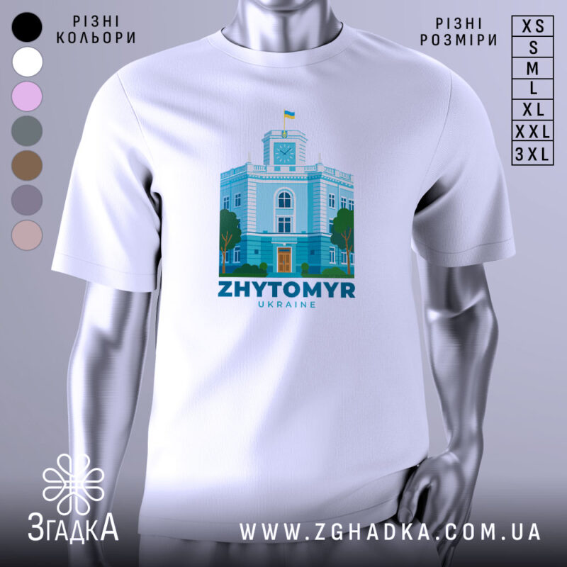Футболка Житомир, біла, зображена на манекені, фон градієнтний сірий, принт з зображенням будівлі з годинником та українським прапором, кольори принта: блакитний, зелений, помаранчевий.