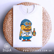 Футболка життя суворе, біла, складена на плетеному кошику, фон світлий, принт з мультяшним персонажем у шапці та окулярах, тримає пляшку, текст на футболці: 'Життя суворе, як я!'.