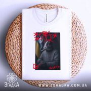 Футболка живи життя, біла, зображена зверху на плетеній кошику, на фоні світло-сірого градієнту, принт з зображенням кролика в светрі з гербом України, з димом та сигаретою, текст "ЖИВИ ЖИТТЯ" червоним кольором.