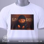 Футболка злий персонаж, біла, зображена зверху, фон світлий, принт з злим персонажем у чорній шапці та куртці, текст на фоні, з етикеткою.