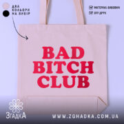 Шопер Bad Bitch Club на світлому фоні, бежевого кольору, з прямим ракурсом, товщина тканини середня, ручки середньої довжини, місткість велика, принт з написом 'BAD BITCH CLUB' червоного кольору.