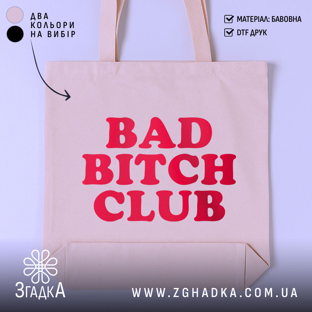 Шопер Bad Bitch Club на світлому фоні, бежевого кольору, з прямим ракурсом, товщина тканини середня, ручки середньої довжини, місткість велика, принт з написом 'BAD BITCH CLUB' червоного кольору.