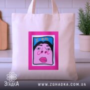 Шопер для класних бежевий, з ракурсом спереду, на фоні кухонних елементів, з тонкої бавовняної тканини, довжина ручок середня, місткість достатня для повсякденних речей, принт з написом 'I am cool' на яскравому рожевому фоні.