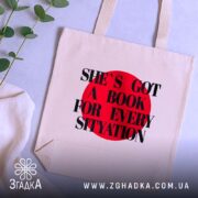 Шопер для книгоманів бежевий на столі поруч із зеленими гілками