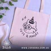 Шопер котик cute angry — кілька складених шоперів, композиція на столі.