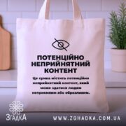 Шопер потенційно неприйнятний контент. Сумка бежевого кольору, зображена з фронтального ракурсу на однотонному фоні. Тканина середньої товщини, ручки середньої довжини, місткість достатня для повсякденних речей, принт чорного кольору з текстом на передній частині.