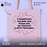 Шопер святковий настрій, бежевий, з фронтальної сторони, на нейтральному фоні, з тонкої бавовняної тканини, ручки середньої довжини, місткий, з принтом у вигляді червоних гірлянд навколо тексту.