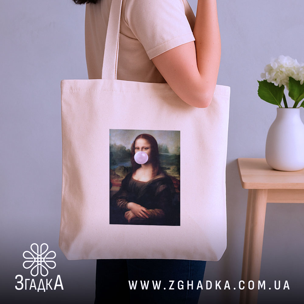 Шопер жартівлива Мона Ліза, бежевий, з бокового ракурсу, на фоні кімнати з вазою, з тонкої бавовняної тканини, з довгими ручками, місткий, з принтом класичної картини Мона Ліза з жувальною гумкою в роті.
