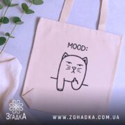 Шопер жартівливий mood котик — кілька складених шоперів, композиція на столі.