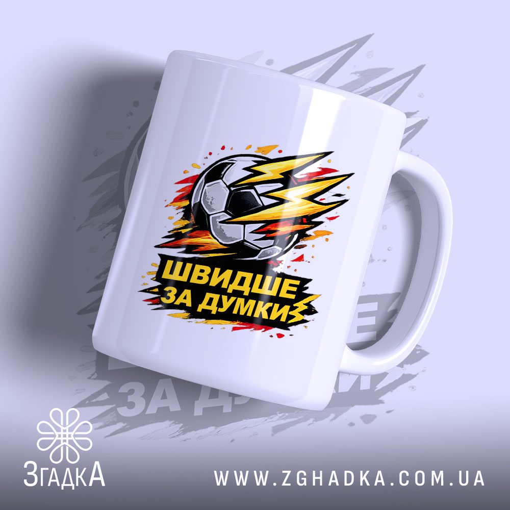 Чашка для футболіста, біла, з ракурсом зліва, на фоні світло-фіолетового кольору, з принтом футбольного м'яча та написом 'ШВИДШЕ ЗА ДУМКИ', ручка класична, край рівний, глянцевий.