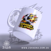 Чашка для футболіста, біла, з ракурсом зліва, на фоні світло-фіолетового кольору, з принтом футбольного м'яча та написом 'ШВИДШЕ ЗА ДУМКИ', ручка класична, край рівний, глянцевий.