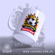 Чашка для короля футболу, біла, зображена з правого ракурсу, фон світло-фіолетовий, принт містить футбольний м'яч, корону та напис "КОРОЛЬ своєї гри МАКСИМ", ручка класична, край рівний, глянець.