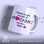 Чашка для подруги. Білий фон, ракурс з правого боку, на чашці чорний текст з написом "Хороша подруга як великий ПОСЮН: не у Всіх буває" та рожеві сердечка. Ручка класична, край рівний, глянцеве покриття.