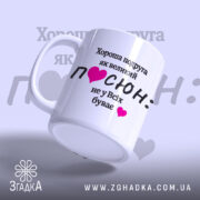 Чашка для подруги. Білий фон, ракурс зліва, на чашці чорний текст з написом "Хороша подруга як великий ПОСЮН: не у Всіх буває" та рожеві сердечка. Ручка класична, край рівний, глянцеве покриття.