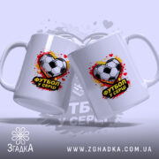 Чашка Футбол у серці, дві чашки, обидві білі, з однаковим принтом футбольного м'яча у формі серця, ручки стандартні, край рівний, фон з розмитими плямами червоного і жовтого кольору, глянцева поверхня.