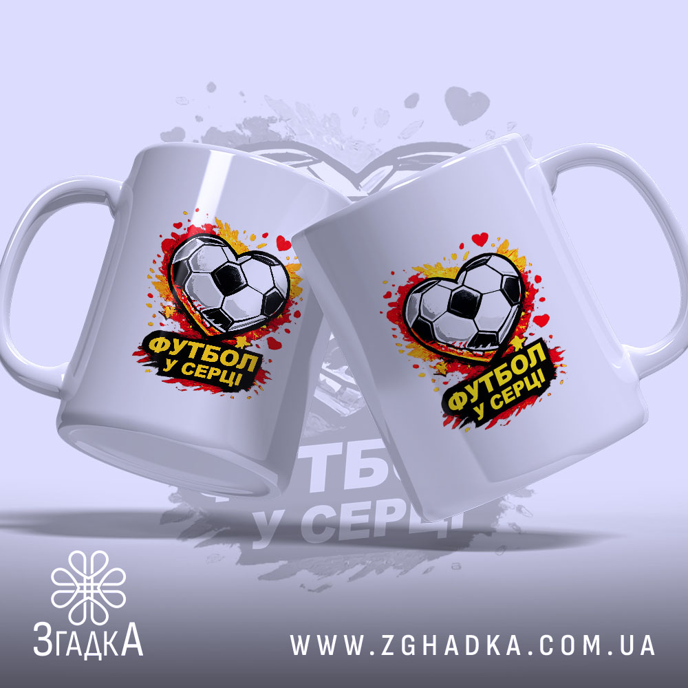 Чашка Футбол у серці, дві чашки, обидві білі, з однаковим принтом футбольного м'яча у формі серця, ручки стандартні, край рівний, фон з розмитими плямами червоного і жовтого кольору, глянцева поверхня.