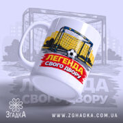 Чашка футбольна Легенда двору, біла, зображення футбольних воріт на жовтому фоні, напис 'ЛЕГЕНДА СВОГО ДВОРУ' червоного кольору, ручка кругла, край рівний, матова поверхня.