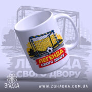 Чашка футбольна Легенда двору, біла, зображення футбольних воріт на жовтому фоні, напис 'ЛЕГЕНДА СВОГО ДВОРУ' червоного кольору, ручка кругла, край рівний, матова поверхня.