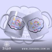 Чашка Я на межі. Дві білі чашки з малюнком єдинорога, що спить на хмарах, розташовані під кутом одна до одної. Ручки гладкі, краї рівні, поверхня глянцева. Фон ніжно-фіолетовий.