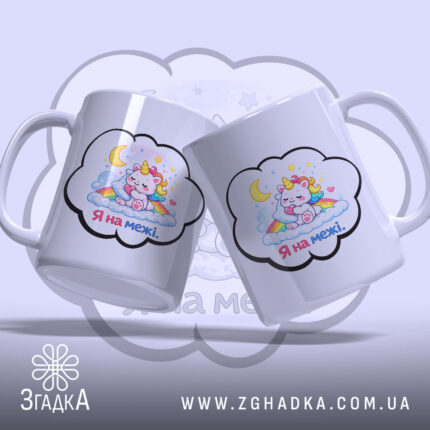 Чашка Я на межі. Дві білі чашки з малюнком єдинорога, що спить на хмарах, розташовані під кутом одна до одної. Ручки гладкі, краї рівні, поверхня глянцева. Фон ніжно-фіолетовий.