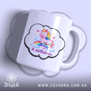 Чашка Я заїбалась прикол, біла, з зображенням єдинорога на веселці, ручка з правого боку, край гладкий, матова поверхня, фон світло-фіолетовий.