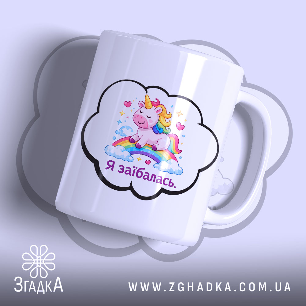 Чашка Я заїбалась прикол, біла, з зображенням єдинорога на веселці, ручка з правого боку, край гладкий, матова поверхня, фон світло-фіолетовий.