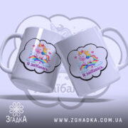 Чашка Я заїбалась прикол, дві білих чашки з однаковим принтом, ручки з обох боків, край гладкий, матова поверхня, фон світло-фіолетовий.