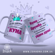 Чашка її величність Кума з двома сторонами, одна з яких має корону та напис про величність, а інша містить текст про дружбу. Обидві чашки мають білий колір з яскравими принтами. Ручки гладкі, а краї рівні. Поверхня матова, фон ніжно-фіолетовий з елементами принта.