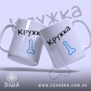 Чашка ЙОГО кружка, дві білі чашки з чорним написом 'Кружка' та синім малюнком, з фронтального ракурсу, фон світло-фіолетовий, ручки класичні, краї рівні, глянцеві.