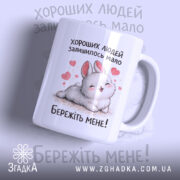 Чашка хороших людей мало. Чашка білого кольору з малюнком милого кролика, що лежить на фоні з сердечками. Ручка чашки гладка, край рівний, поверхня глянцева. На чашці напис: 'Бережіть мене!'