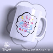 Чашка подарунок з зайчиком, біла з кольоровим принтом, зображення зайчика на хмарі з чашкою, напис 'Я в ахуї' під зайчиком, ручка класична, край рівний, глянцева поверхня.