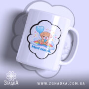 Чашка прикол мені всеодно біла, з зображенням милого цуценяти, що тримає повітряну кулю. Принт оточений хмаринкою, на якій написано 'Менi похуй'. Ручка чашки гладка, край рівний, поверхня глянцева.