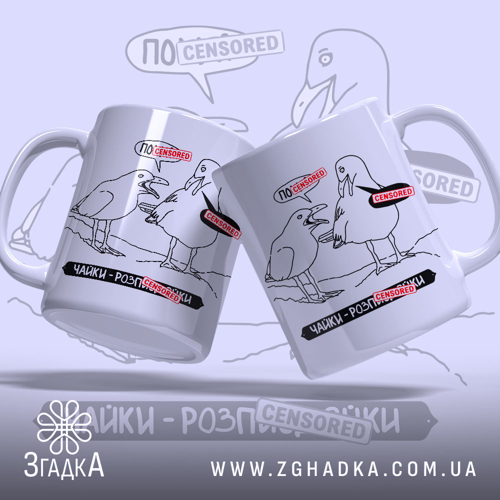 Чашка прикол про чайок: дві білі чашки, що стоять під кутом, з чорними малюнками чайок та червоними написами 'ЦЕНЗУРА'. Ручки гладкі, краї рівні, поверхня матова. Фон світло-сірий з розмитими елементами.