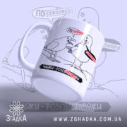 Чашка прикол про чайок: біла чашка з чорним малюнком двох чайок, одна з яких говорить, з червоними написами 'ЦЕНЗУРА'. Ручка гладка, край рівний, поверхня матова. Фон світло-сірий з розмитими елементами.