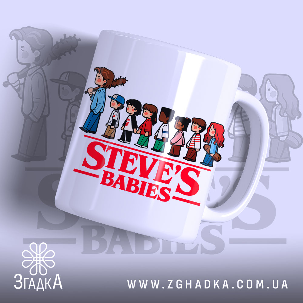 Чашка Steve's Babies має білий фон з яскравим червоним написом 'STEVE'S BABIES' на передній частині, з малюнками дітей, що стоять в ряд. Ручка чашки гладка, край рівний, а поверхня має легкий глянець.
