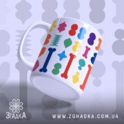 Чашка цікава геометрична, біла з кольоровими принтами, зображена під кутом, фон світло-сірий, ручка стандартна, край рівний, глянцева поверхня.