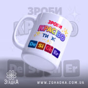 Чашка Ти ж Дизайнер. Чашка білого кольору з яскравим принтом 'ЗРОБИ КРАСИВО ТИ Ж'. Ручка класичної форми, край рівний, поверхня глянцева. Фон світло-фіолетовий з розмитими елементами.