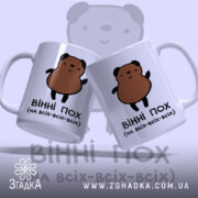 Чашка ведмідь пофігіст, дві білі чашки з малюнком ведмедя, ракурс з фронту, фон світло-синій, принт з ведмедем коричневого кольору, ручки стандартні, краї рівні, матова поверхня.