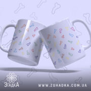 Чашка з кольоровими піструнами, дві однакові чашки з малюнками кісточок, зображені під кутом, фон світло-фіолетовий, ручки стандартні, краї рівні, глянцева поверхня.