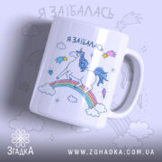 Чашка з втомленим єдинорогом, білого кольору, з ракурсом спереду, на фоні світло-фіолетового кольору, з принтом єдинорога на веселці, написом 'я заїбалась' у верхній частині, ручка стандартної форми, край рівний, глянцевий.