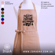 Фартух готую без паніки, бежевого кольору, зображений на манекені, фон світлий, принт чорного кольору з кухонними атрибутами.