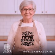 Фартух готую без паніки, бежевого кольору, зображений на манекені, фон світлий, принт чорного кольору з кухонними атрибутами.