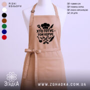 Фартух хто готує керує, бежевий колір, зображення з фронтального ракурсу, фон світлий, принт чорного кольору з кухонними атрибутами.