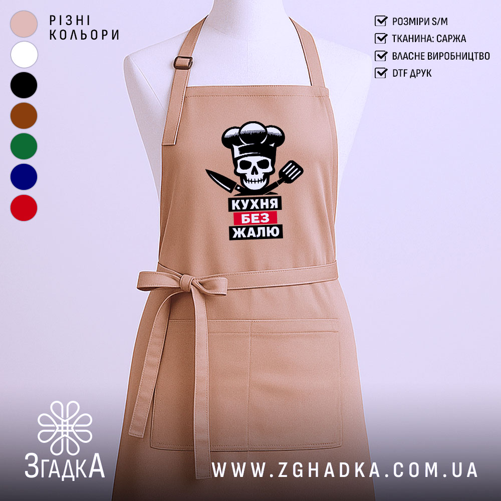 Фартух кухня без жалю, бежевого кольору, зображений на манекені, фон світлий, принт з черепом, кухарським ковпаком та кухонними приладдями.