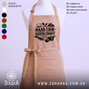 Фартух мало слів, бежевий колір, зображений на манекені з правого ракурсу, фон світлий, принт чорного кольору з написом 'МАЛО СЛІВ - БАГАТО СМАКУ' та кухонними атрибутами.